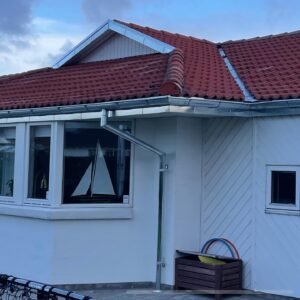 House with red roof, window, and rain gutters.